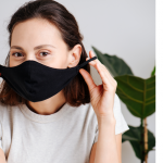 A virtual event represented by a woman holding a face mask over her mouth.