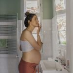 Pregnant woman using safe pregnancy skin care product